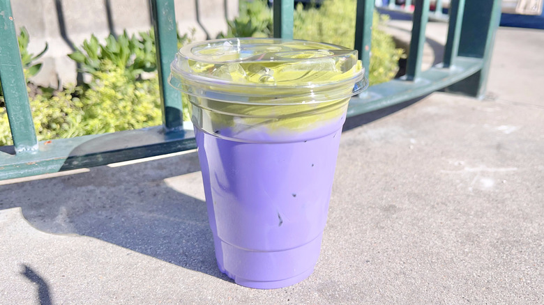 Ube Latte with Matcha Foam in a clear cup on concrete