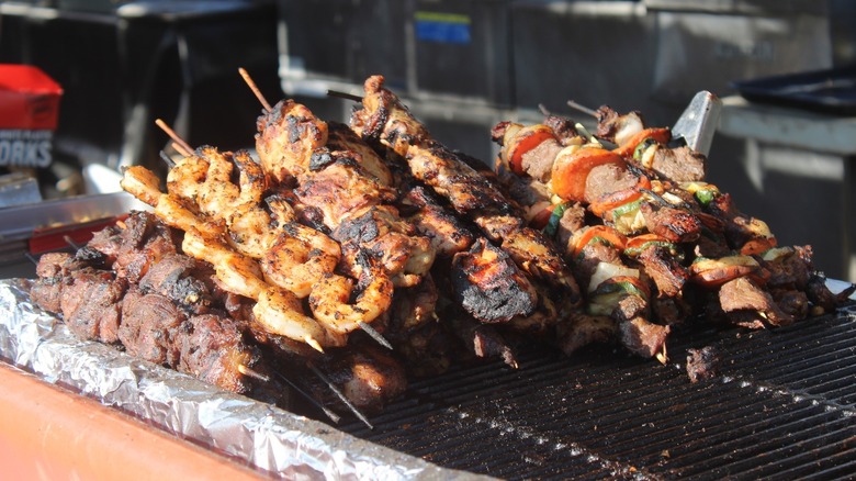 Meat, veggie, and shrimp skewers on a grill at the Biloxi Seafood Festival