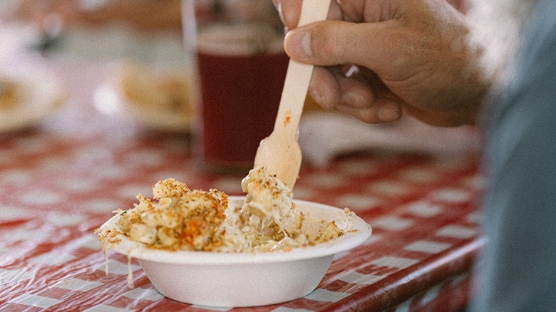 Hand holding a fork and scooping a crab dish at the Astoria Warrenton Crab and Wine Fest