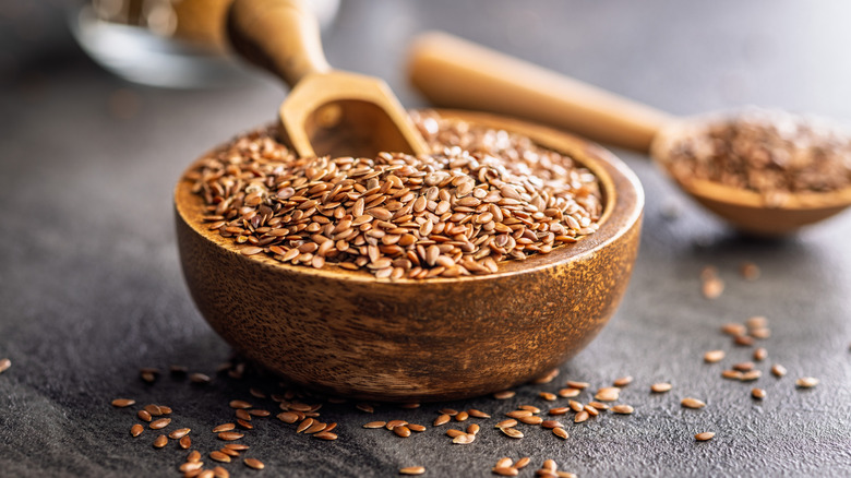 Flaxseeds in a wooden bowl with a wooden scoop