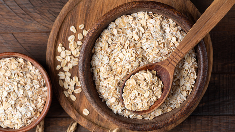 Oats in wooden bowls with a wooden spoon