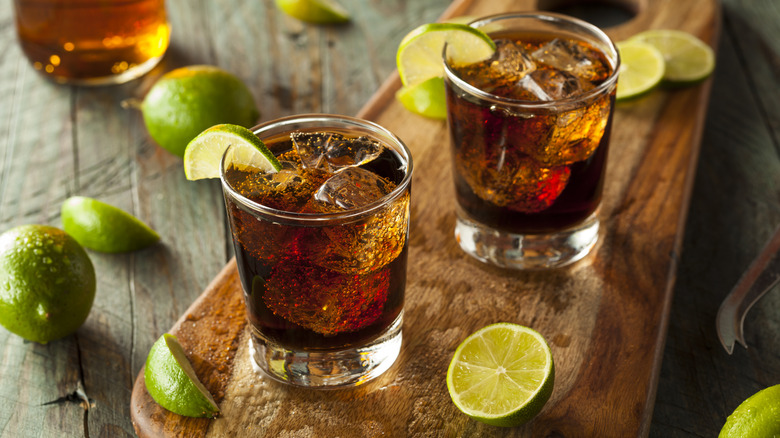 Two Cuba libre drinks in glasses with limes