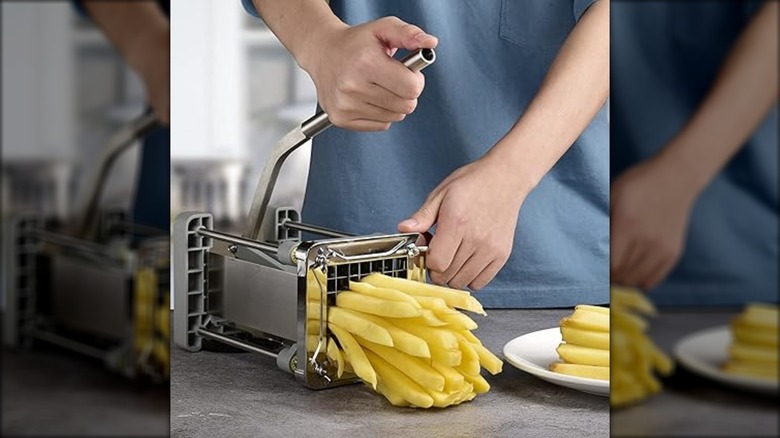 A person cutting a potato with a Sopito french fry cutter