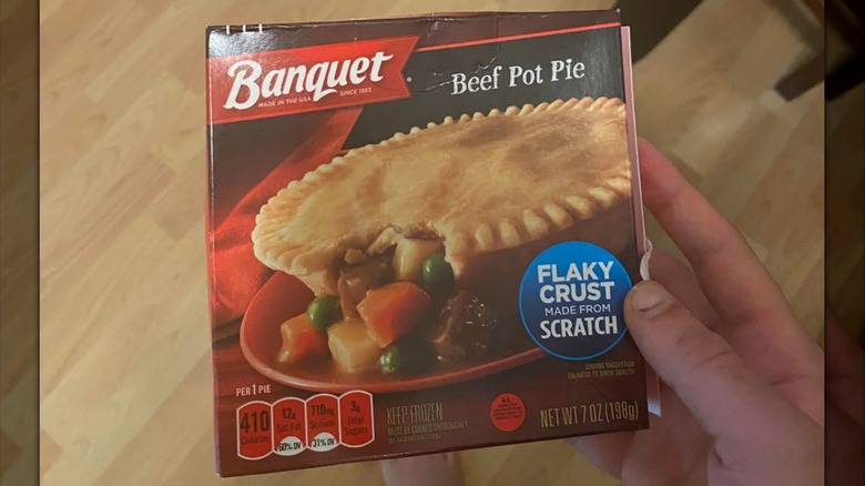 A Banquet beef pot pie box, one side torn open, sitting on a marble countertop