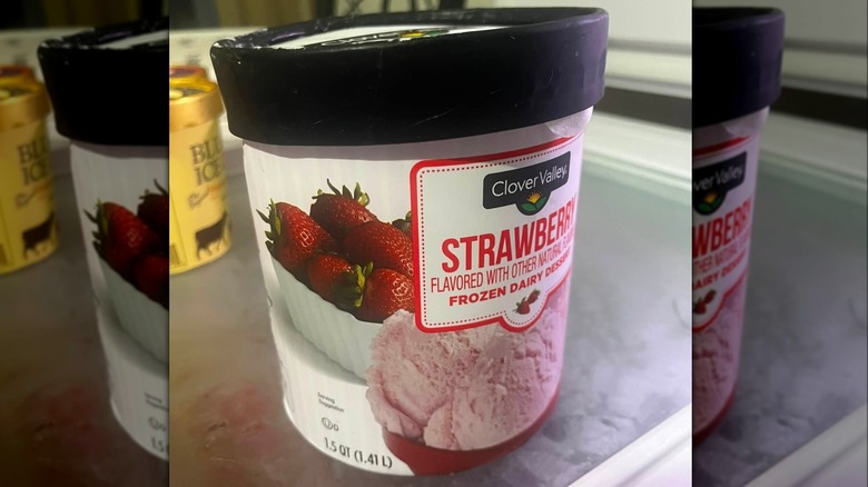 A container of Clover Valley brand strawberry frozen dairy dessert sitting on a counter