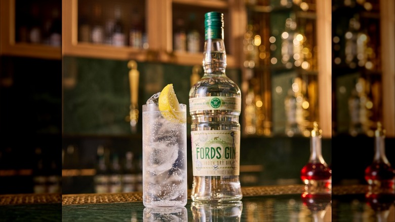 Bottle of Fords Gin next to a gin and tonic on a bar