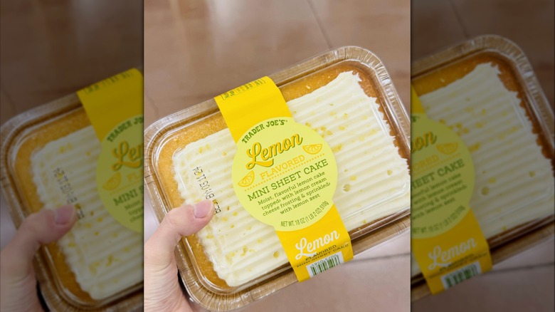 A person holding a container of Trader Joe's Lemon Flavored mini sheet cake
