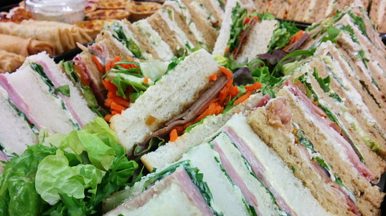 Close-up of a sandwich platter with various meat- and veggie-filled sandwich triangles