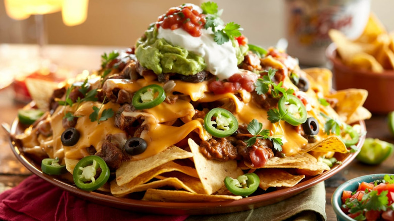 A loaded plate of nachos with tons of toppings