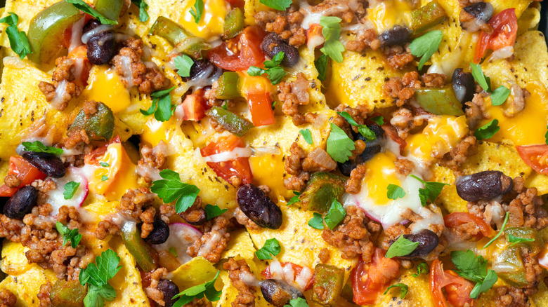 a close up of nachos loaded with toppings
