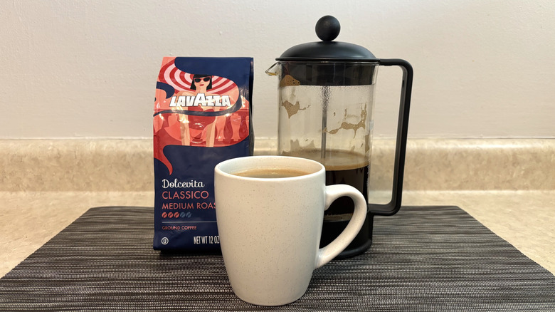 Lavazzo Dolcevita classico in bag, cup, and french press on black placemat
