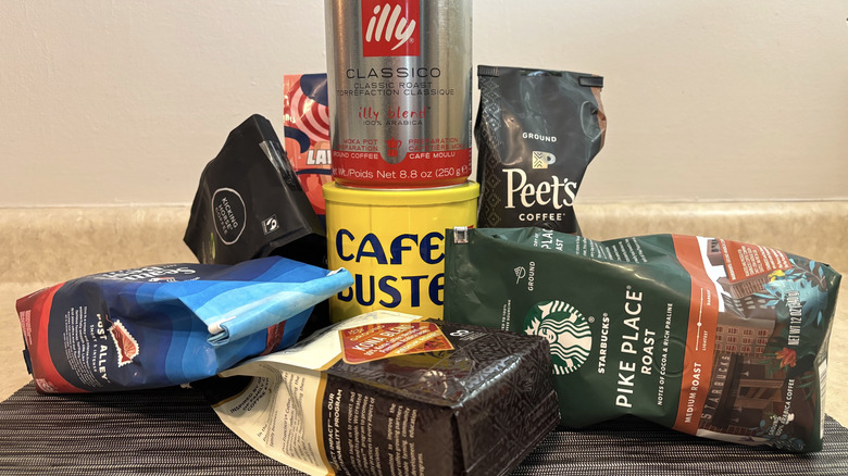 A variety of ground store-bought coffee on black placemat