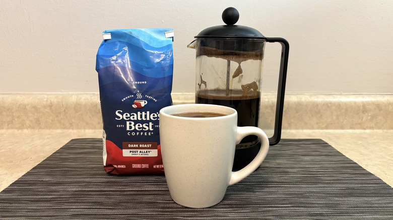 Seattle's Best Post Alley blend in bag, french press, and cup on black placemat