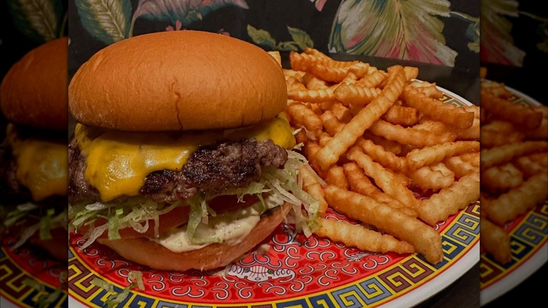 Cheeseburger and fries on a brightly-colored plate