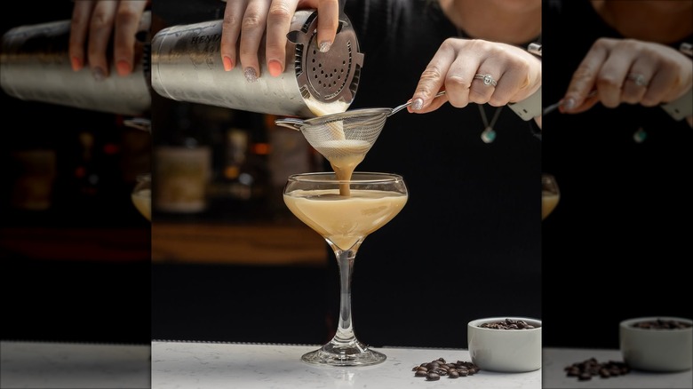 bartender pouring an espresso martini into a glass