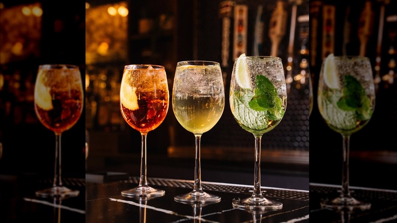 three types of spritz drinks on a bar top