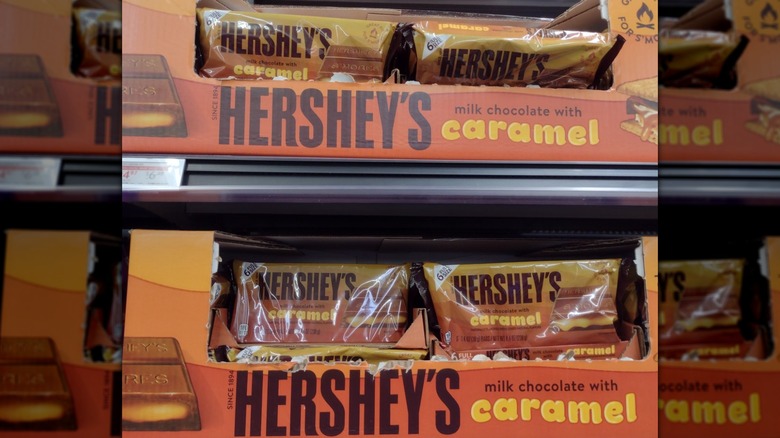 Boxes of Hershey's Milk Chocolate with Caramel bars in a candy aisle