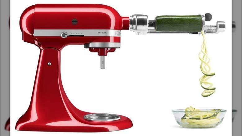Red KitchenAid stand mixer with attachment spiralizing zucchini