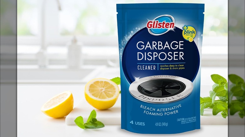 Package of Glisten Garbage Disposer Cleaner on counter with lemon and mint