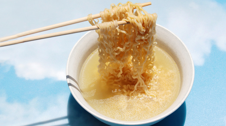Foodie eating a bowl of Maruchan Instant Ramen with chopsticks