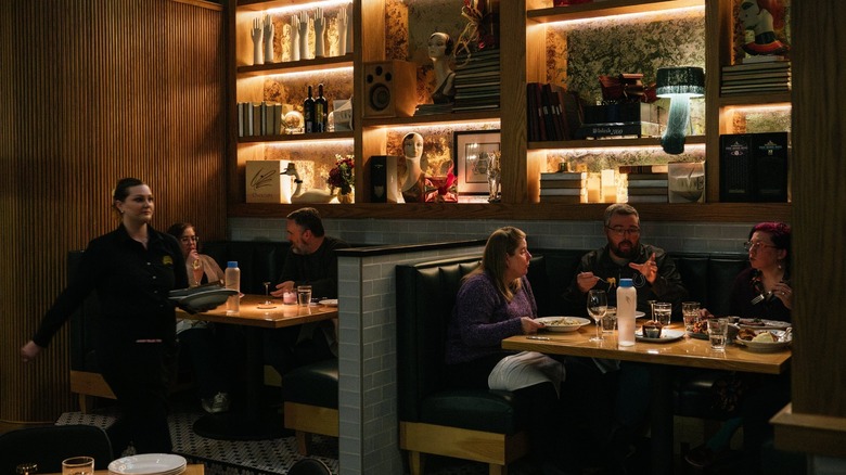 People eating at booths in an upmarket supper club