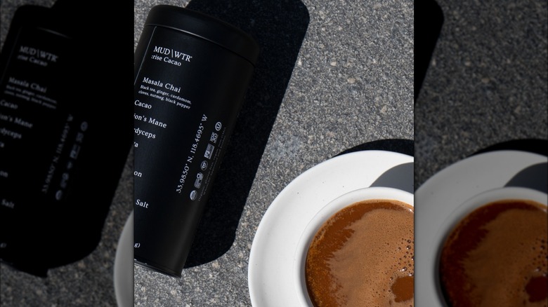 MUD/WTR can and cup of coffee on the pavement outside