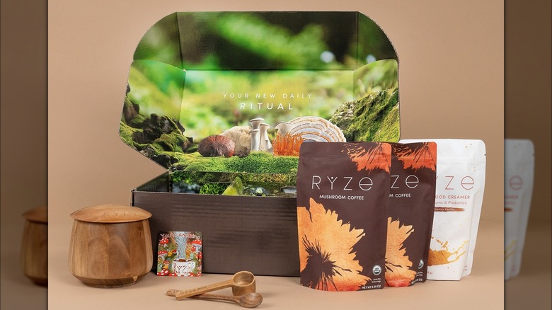 Open box with Ryze coffee packages and wooden scoop and cup
