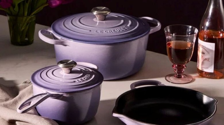 Le Creuset cast iron pots in Provence purple color on kitchen counter next to bottle of rose wine