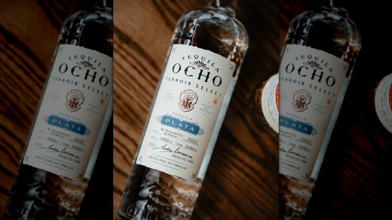 Bottle of Tequila Ocho Terroir Select Comunidad Plata on wooden surface