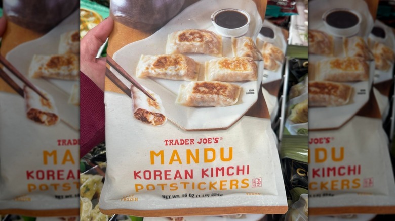 A person holding a package of Trader Joe's Mandu Korean Kimchi Potstickers