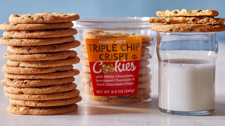 A stack of cookies and a glass of milk next to a package of Trader Joe's Triple Chip Crispy Cookies