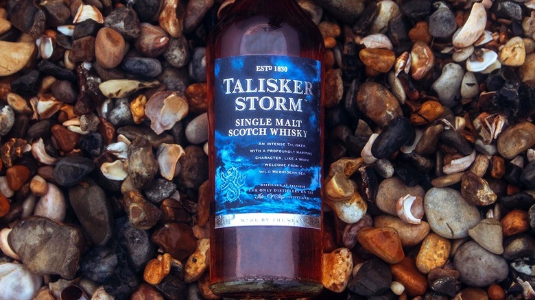 Top-down view of a bottle of Talisker Storm laid down on pebbles