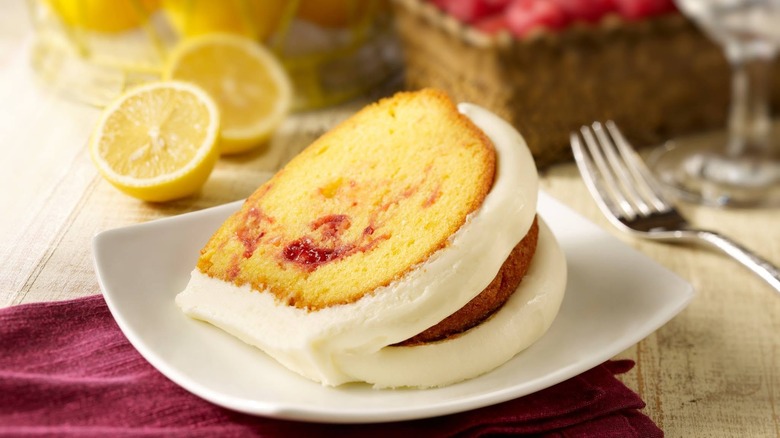 Big slice of lemon raspberry bundt cake next to fresh fruit