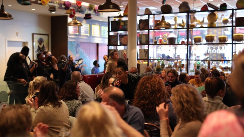 People at tables listening to live music performace in the background