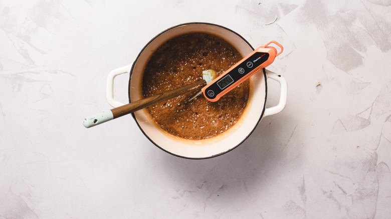 Candy mixture with thermometer in white pot