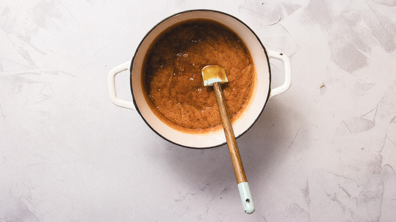 Bubbling candy mixture with spatula in white pot