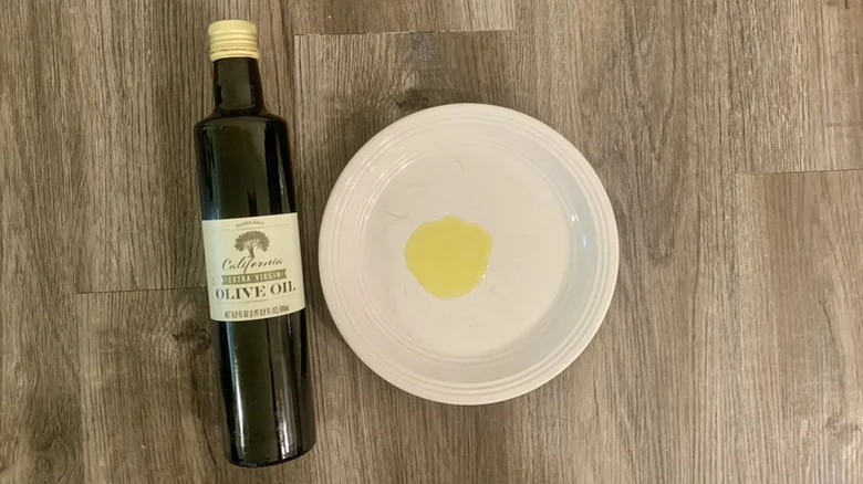 Bottle of Trader Joe's California Olive Oil poured on white plate