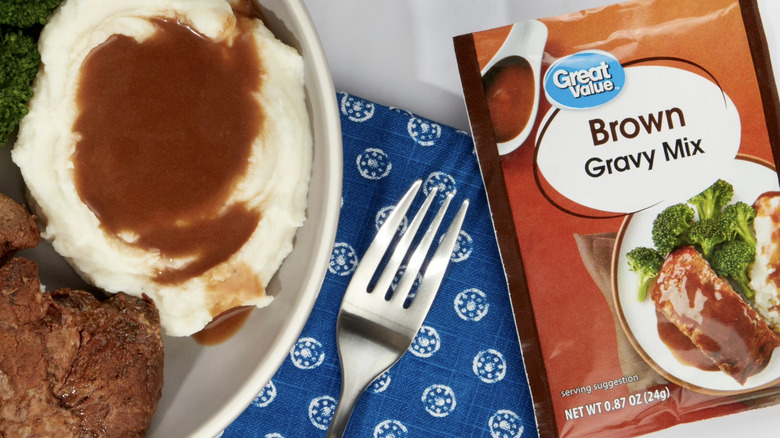 Mashed potatoes topped with gravy, pictured alongside a gravy packet