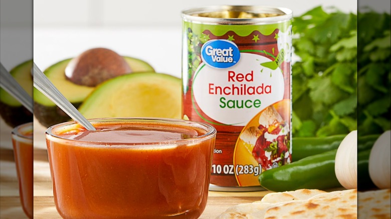 A bowl of red sauce in the forefront with a can of Red Enchilada Sauce in the background