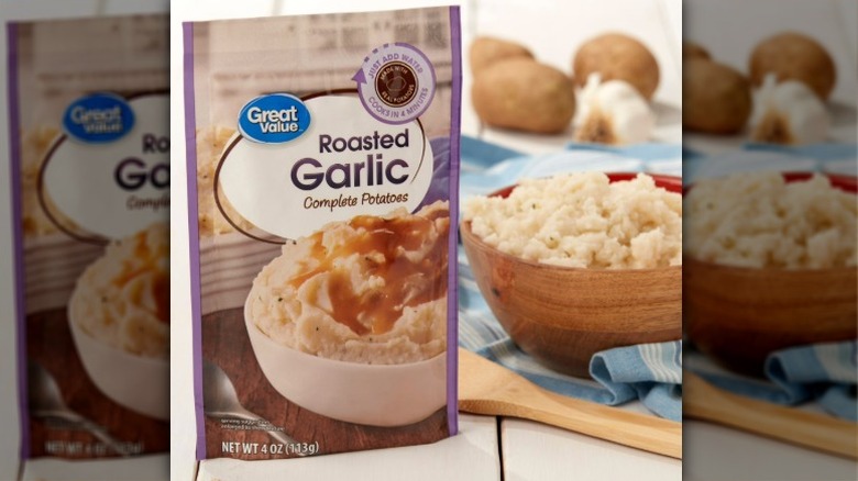 A bowl of mashed potatoes pictured next to a Great Value Roasted Garlic ready-made potatoes package