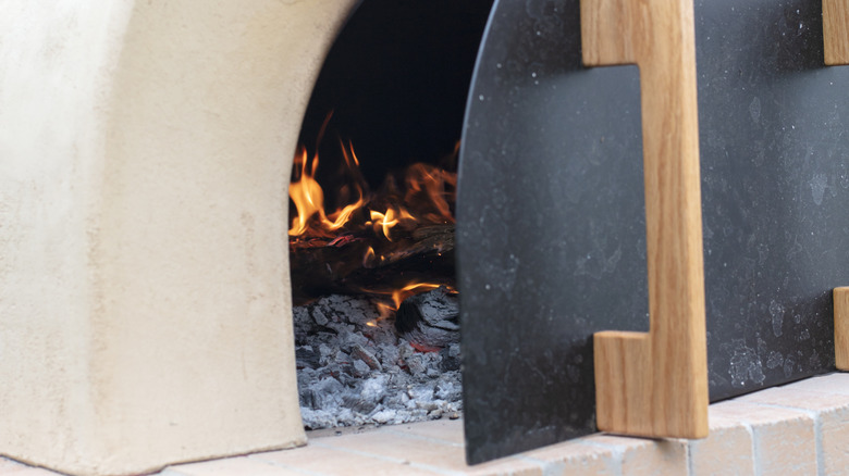 The door of a pizza oven, slightly ajar