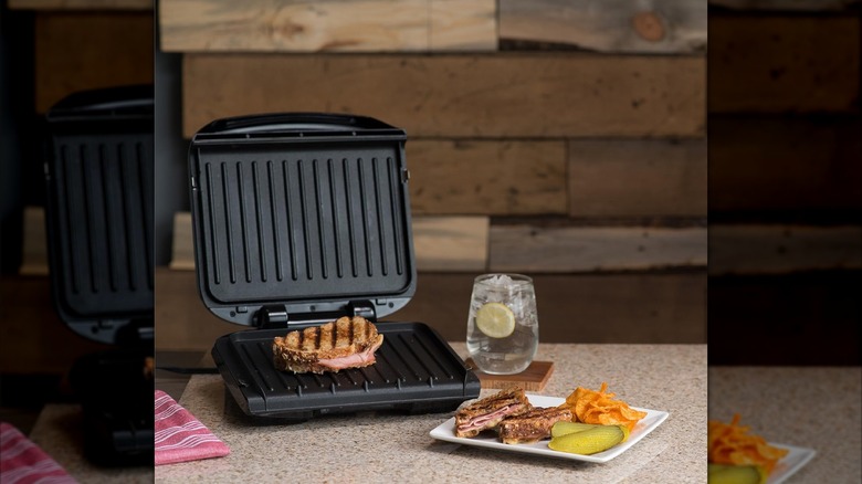 A George Foreman panini press with a plate of food