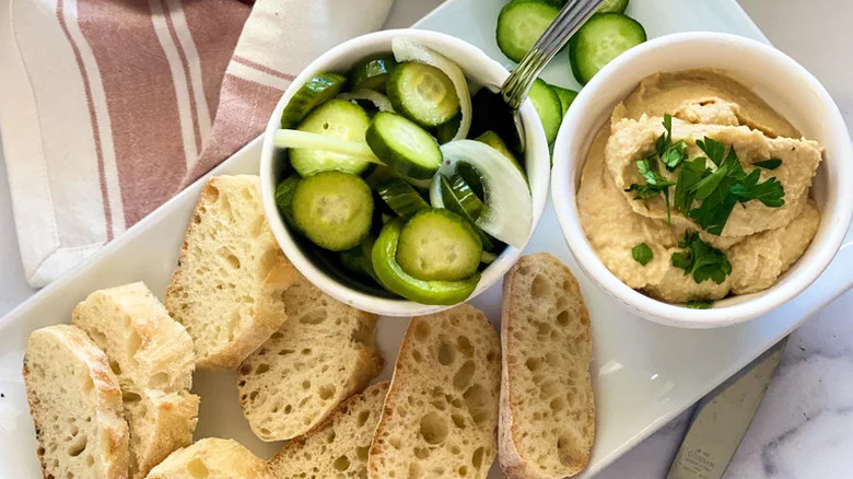 Easy Spicy Freezer Pickles with hummus and bread on plate
