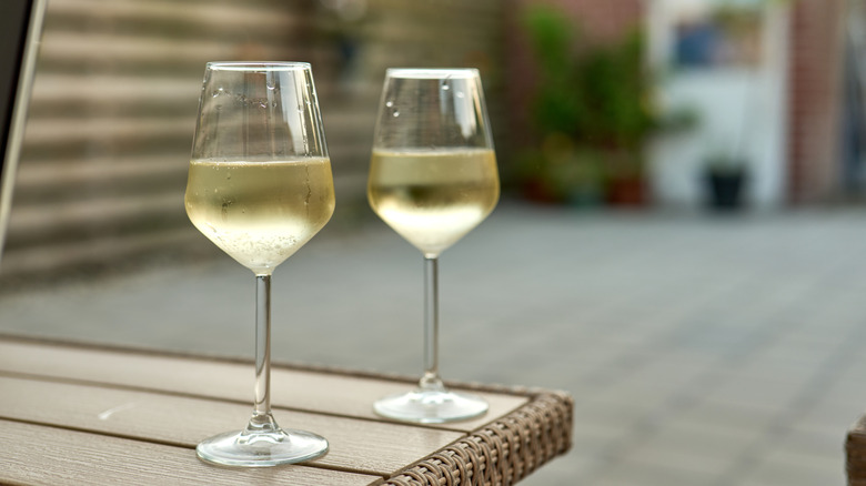 Two glasses of chilled white wine on a table outdoors