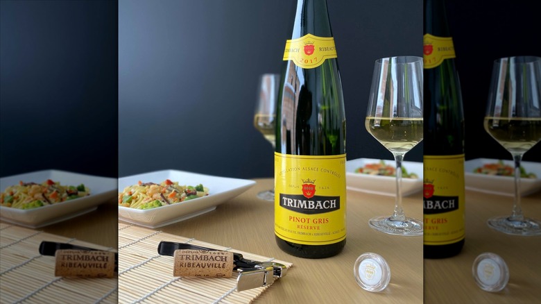 Trimbach Pinot Gris Alsace Réserve bottle on a table with two glasses and meals