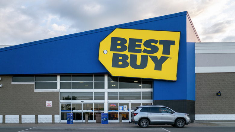 Best Buy store with bright blue exterior and yellow price tag-shaped sign showing store name