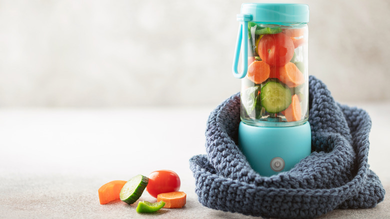 A portable blender with various fruits