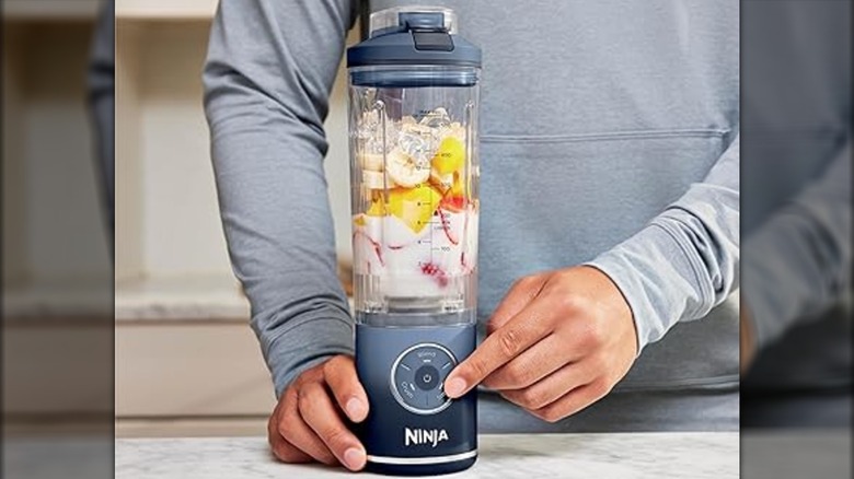 A person using a Ninja Blast portable blender