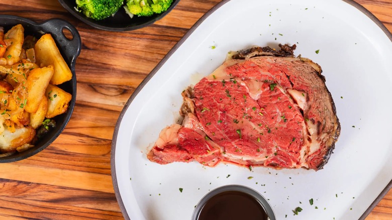 Prime rib on tray with sides of broccoli and potatoes