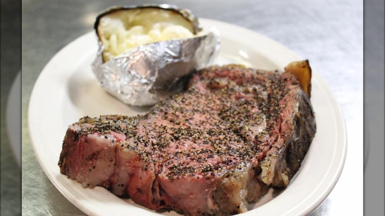 Prime rib on plate with baked potato